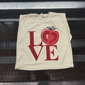 A cream-colored short-sleeve t-shirt with a red graphic print spelling 'LOVE' where the 'O' is a tomato slice, placed on a black metal rolling rack.